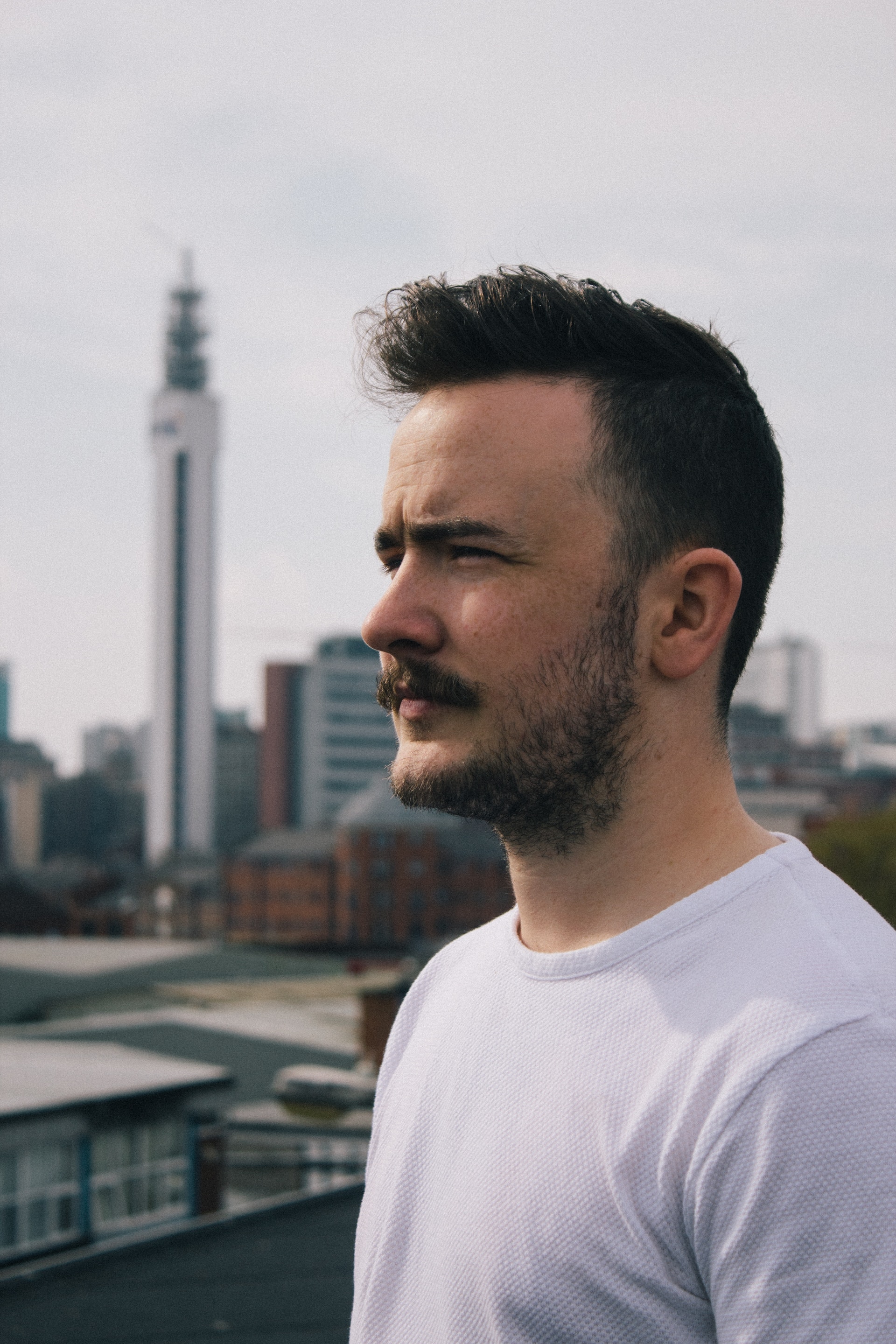 A picture of a white man standing on top of a roof